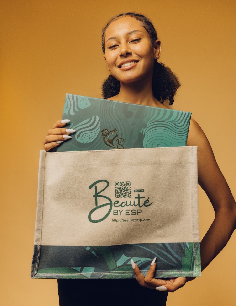 Woman holding Beauté by ESP branded tote bag with packaged skincare products