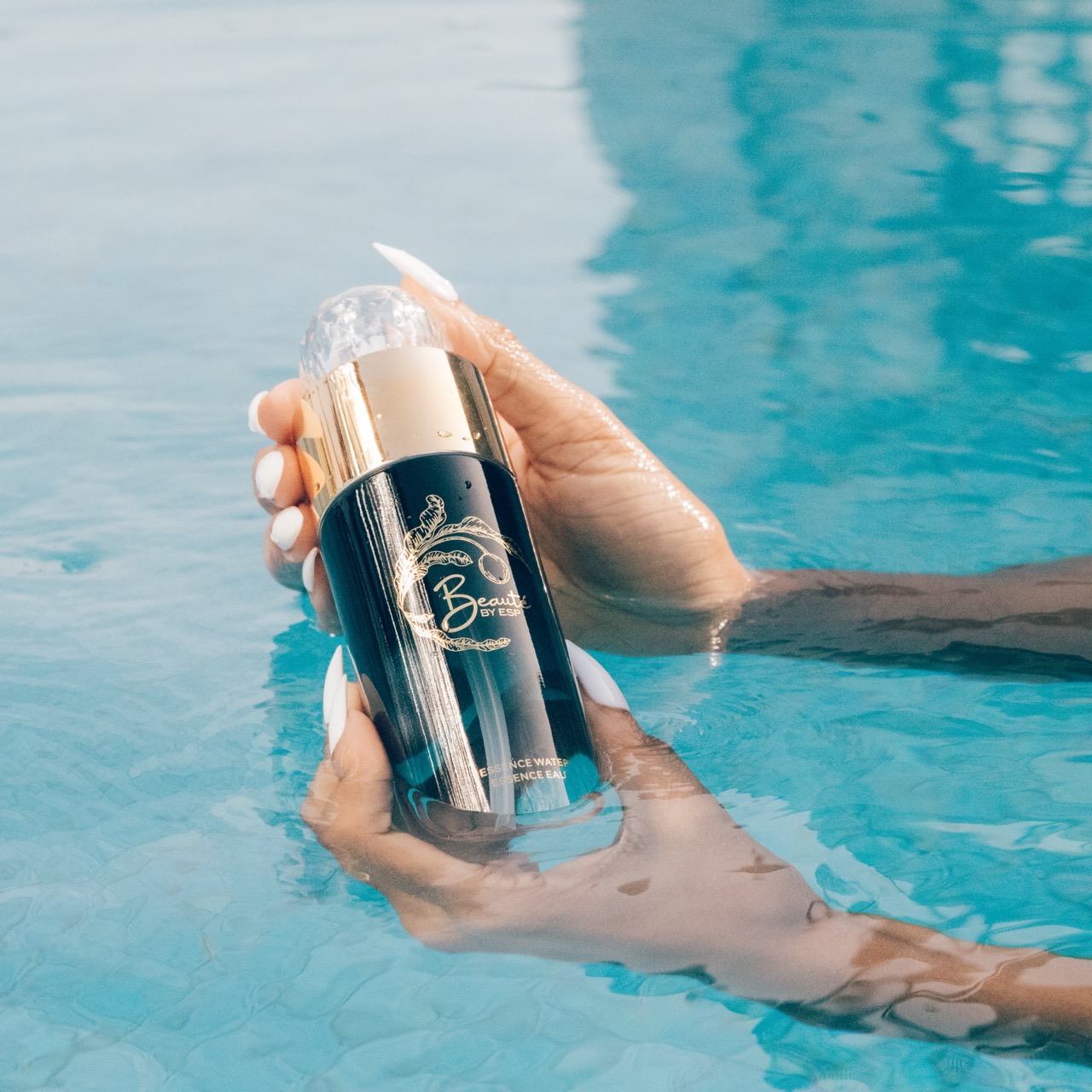Woman holding Beauté by ESP Essence Water in pool showing refreshing hydration and product glow